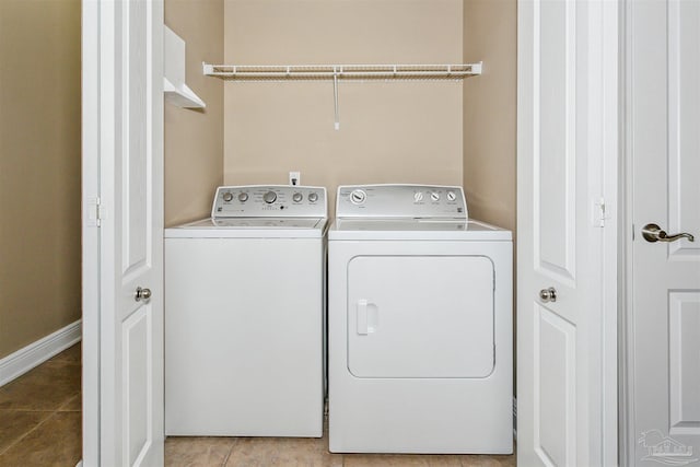 clothes washing area featuring light tile patterned floors, laundry area, and washer and dryer