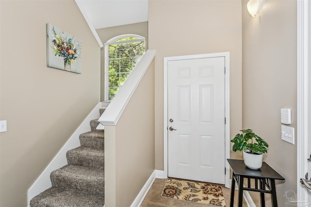 tiled entrance foyer featuring vaulted ceiling