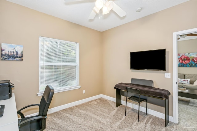 carpeted home office featuring ceiling fan