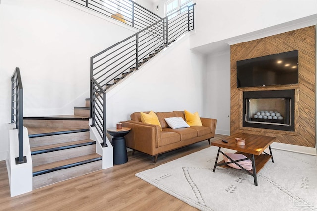 13844 Red Drum Ct, Perdido Key, FL 32507 - living area featuring wood finished floors, stairs, a large fireplace, and a high ceiling
