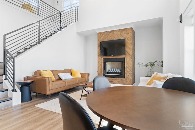 13844 Red Drum Ct, Perdido Key, FL 32507 - living area featuring a large fireplace, stairway, wood finished floors, and a towering ceiling