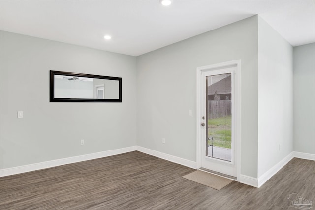 empty room featuring recessed lighting, wood finished floors, and baseboards