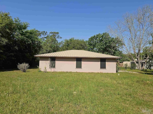 12741 S Santa Piedro, Lillian, AL 36549 - view of property exterior with a lawn, stucco siding, and metal roof