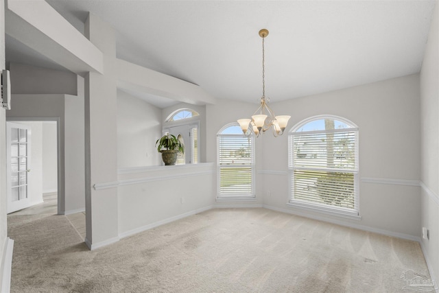 unfurnished dining area with a chandelier, carpet flooring, baseboards, and vaulted ceiling