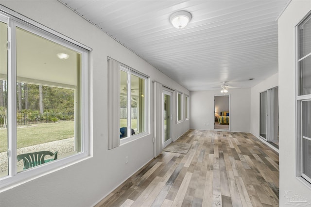 unfurnished sunroom featuring a ceiling fan