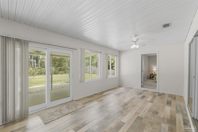 unfurnished sunroom featuring visible vents, plenty of natural light, and ceiling fan