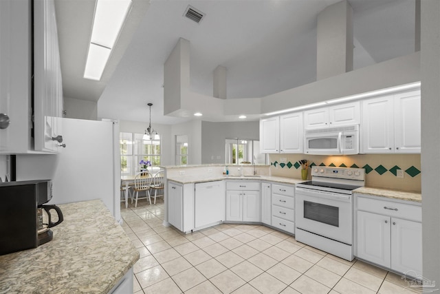 kitchen featuring light tile patterned floors, a peninsula, white appliances, white cabinetry, and a sink