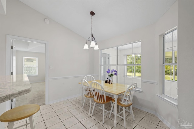 dining area with an inviting chandelier, lofted ceiling, light tile patterned flooring, and baseboards