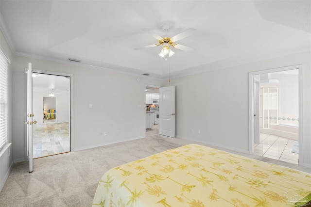 bedroom with a raised ceiling, ensuite bathroom, crown molding, baseboards, and light colored carpet