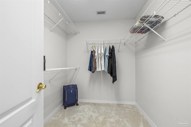 walk in closet featuring visible vents and carpet flooring