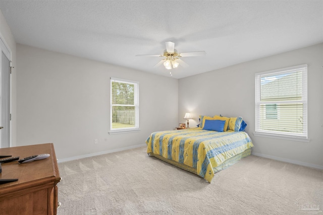 carpeted bedroom featuring baseboards, a textured ceiling, and ceiling fan