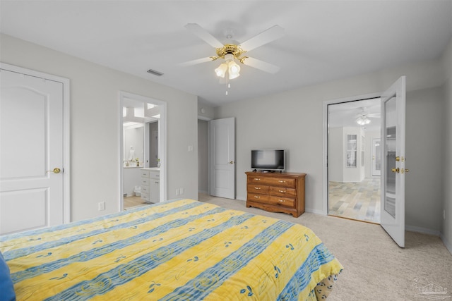 carpeted bedroom with visible vents, a ceiling fan, ensuite bathroom, and baseboards