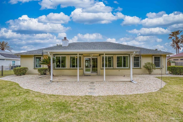 rear view of house featuring a shingled roof, fence, stucco siding, a lawn, and a patio