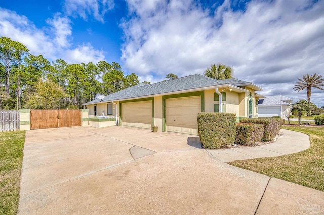 view of home's exterior featuring a shingled roof, fence, stucco siding, driveway, and an attached garage