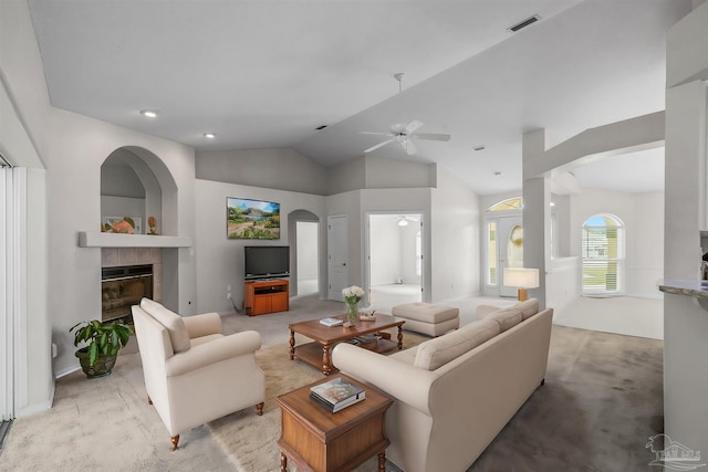 living area with visible vents, light colored carpet, lofted ceiling, a fireplace, and a ceiling fan