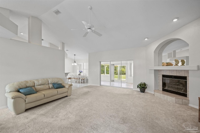 carpeted living room featuring a ceiling fan, baseboards, visible vents, high vaulted ceiling, and a tiled fireplace