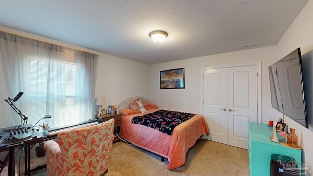 bedroom featuring light carpet and a textured ceiling