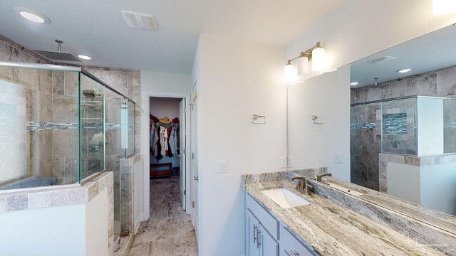 bathroom with vanity and a shower with door