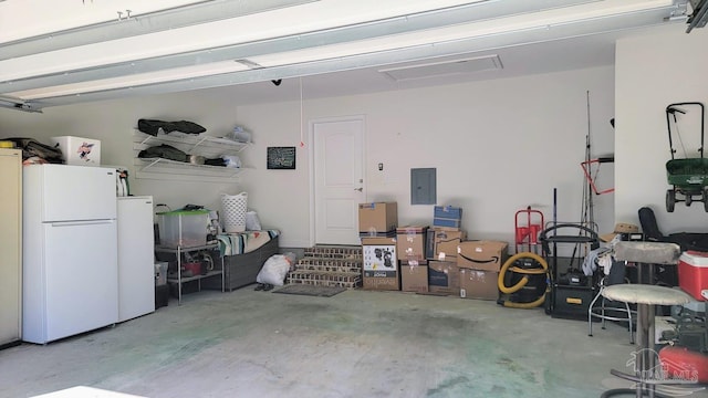 garage featuring electric panel and white fridge