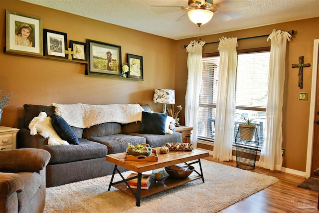 living room featuring ceiling fan, hardwood / wood-style floors, a textured ceiling, and a healthy amount of sunlight