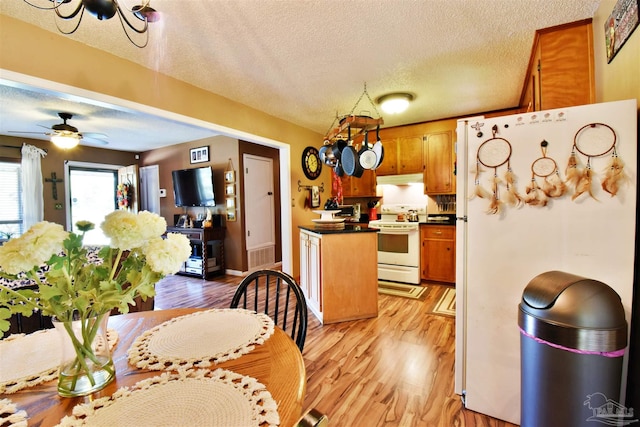 kitchen featuring ceiling fan, white appliances, light hardwood / wood-style floors, and a textured ceiling