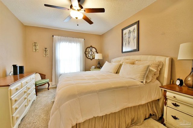 bedroom with light carpet, ceiling fan, and a textured ceiling