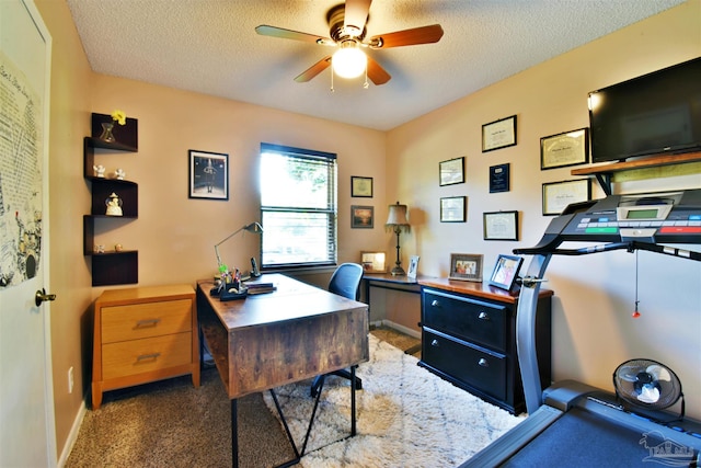 office space featuring ceiling fan, dark carpet, and a textured ceiling