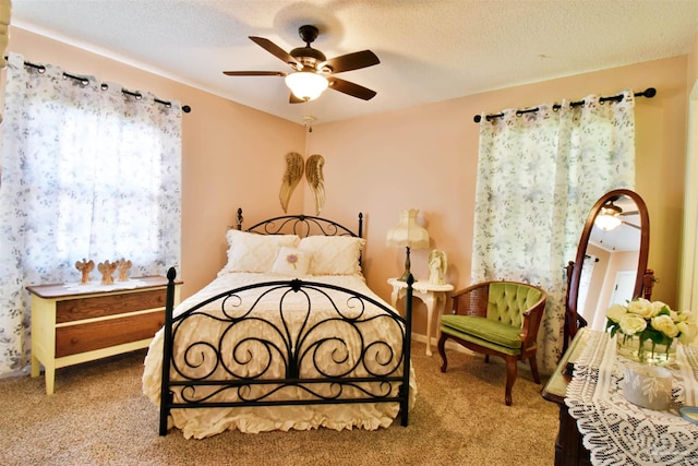 carpeted bedroom featuring a textured ceiling and ceiling fan