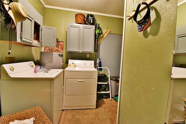 laundry room with washing machine and clothes dryer, cabinets, and a textured ceiling