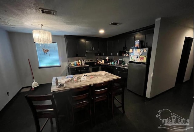 kitchen with decorative light fixtures, a kitchen bar, appliances with stainless steel finishes, and a chandelier