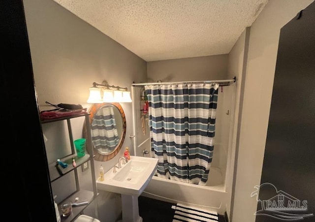 bathroom featuring sink, a textured ceiling, and shower / tub combo