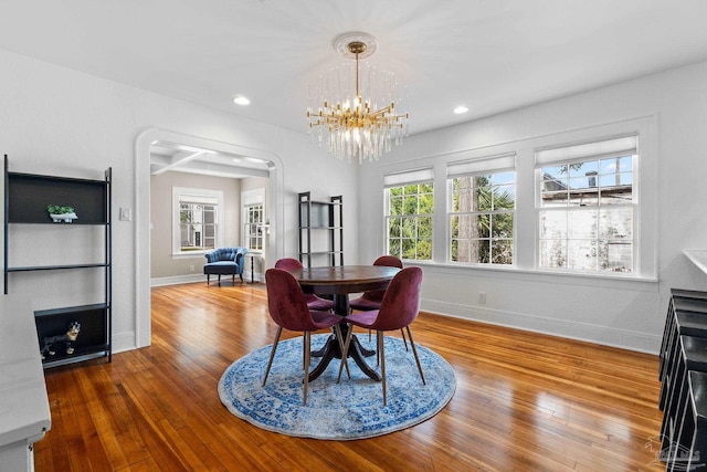 dining area featuring wood-type flooring and an inviting chandelier