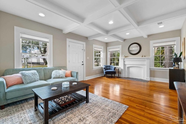 living room featuring beamed ceiling, wood-type flooring, a healthy amount of sunlight, and coffered ceiling