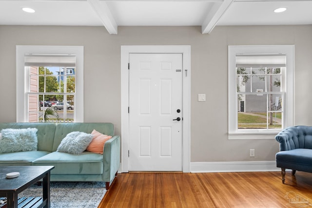 foyer featuring a wealth of natural light, hardwood / wood-style flooring, and beam ceiling