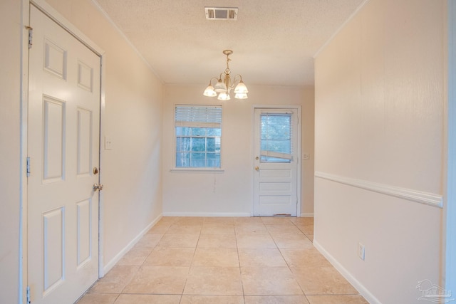 entryway with light tile patterned flooring, a chandelier, and a textured ceiling