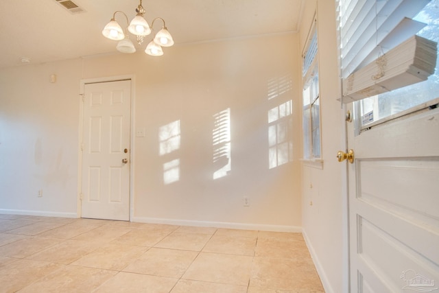 entrance foyer with a notable chandelier, a healthy amount of sunlight, and light tile patterned floors