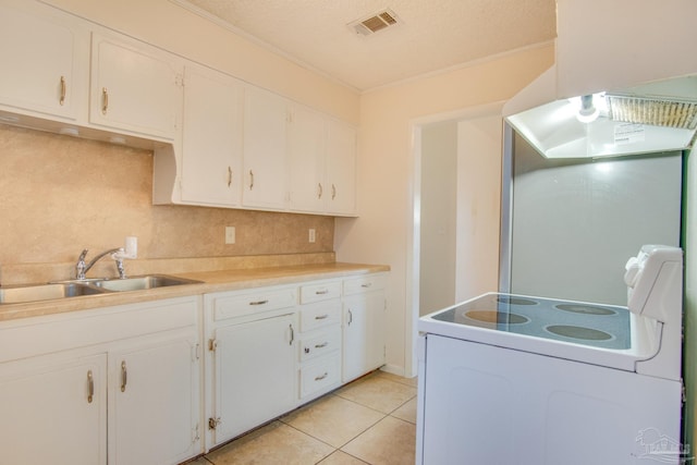 kitchen featuring a textured ceiling, white cabinetry, and sink