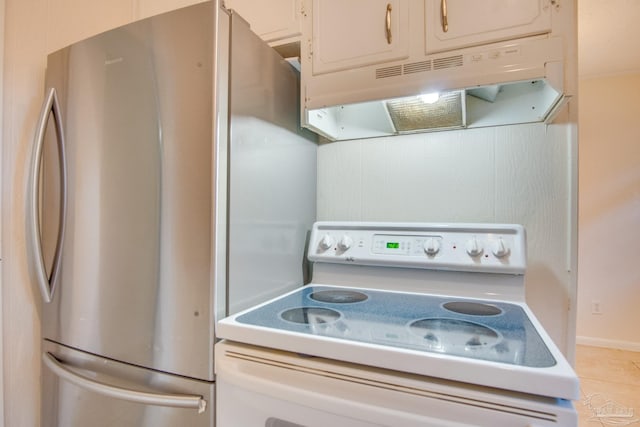 kitchen featuring white cabinets, stainless steel fridge, light tile patterned floors, and white electric range oven