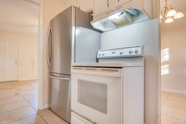 kitchen featuring stainless steel fridge, light tile patterned floors, white electric range oven, and an inviting chandelier