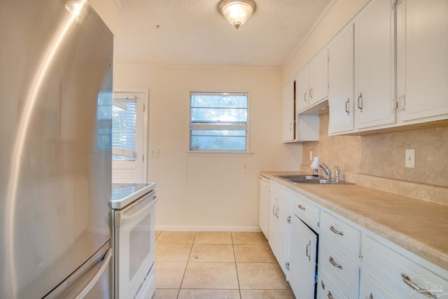 kitchen featuring stainless steel refrigerator, white cabinetry, sink, white range, and a textured ceiling