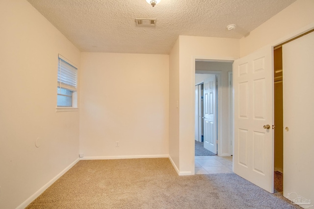 carpeted spare room featuring a textured ceiling