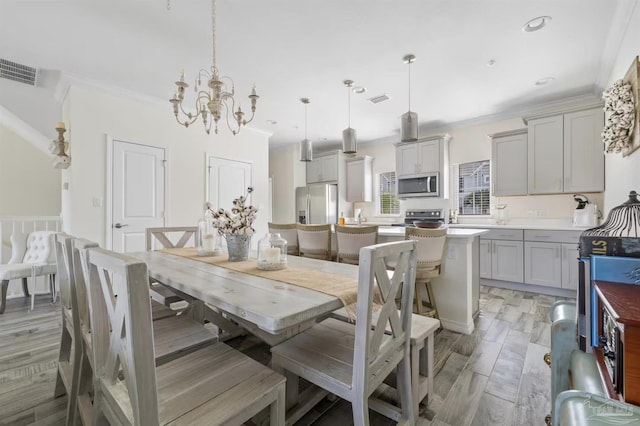 14478 Salt Meadow Dr, Pensacola, FL 32507 - dining space with a chandelier, ornamental molding, and light wood-style flooring
