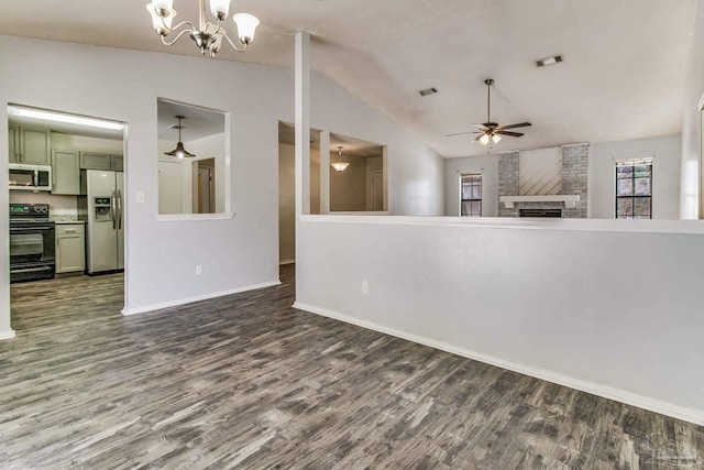 unfurnished living room with lofted ceiling, dark wood-type flooring, ceiling fan with notable chandelier, and a brick fireplace