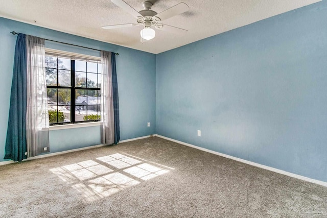 carpeted empty room with ceiling fan and a textured ceiling