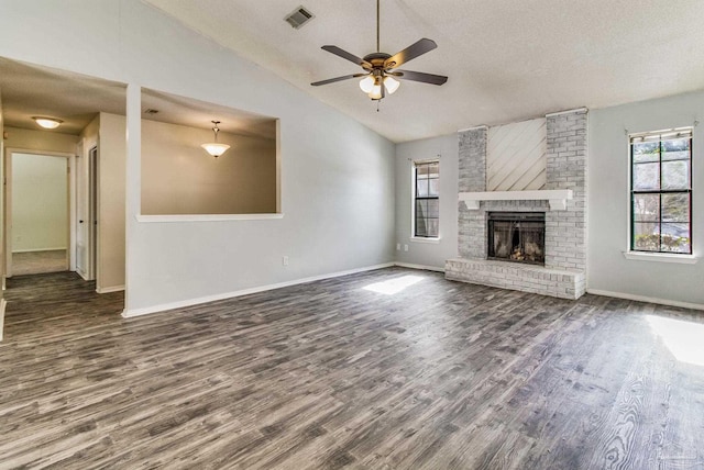 unfurnished living room with dark hardwood / wood-style flooring, a fireplace, vaulted ceiling, and a textured ceiling