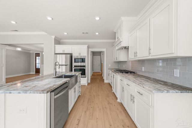 6264 Howie Way, Pace, FL 32571 - kitchen featuring stainless steel appliances, white cabinetry, an island with sink, decorative backsplash, and ornamental molding