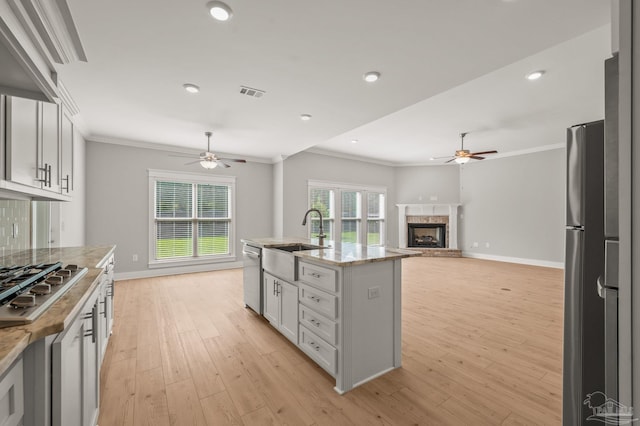 6264 Howie Way, Pace, FL 32571 - kitchen with a ceiling fan, crown molding, appliances with stainless steel finishes, a fireplace, and open floor plan