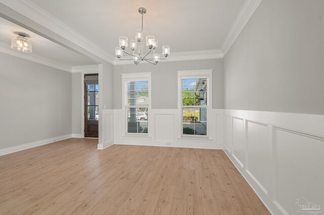 6264 Howie Way, Pace, FL 32571 - unfurnished dining area featuring light wood-type flooring, a chandelier, a wainscoted wall, crown molding, and a decorative wall