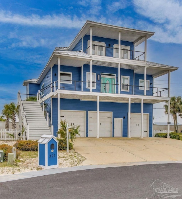 coastal inspired home featuring metal roof, driveway, and an attached garage