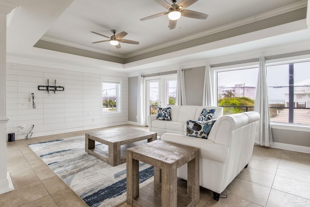 living room with crown molding, a ceiling fan, plenty of natural light, and light tile patterned flooring
